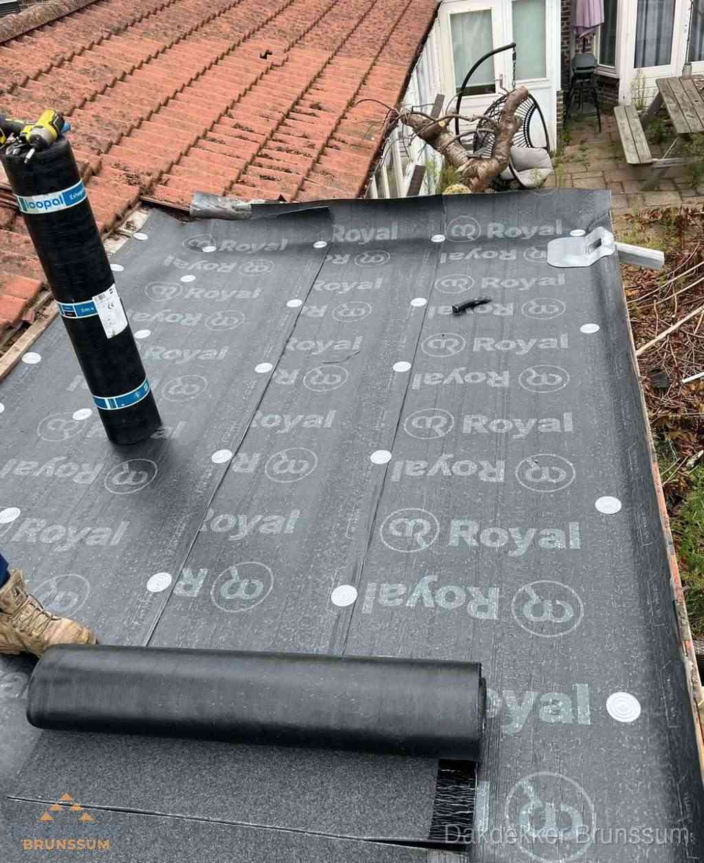 Plat dak met nieuwe bitumen dakbedekking en brandgereedschap in Brunssum