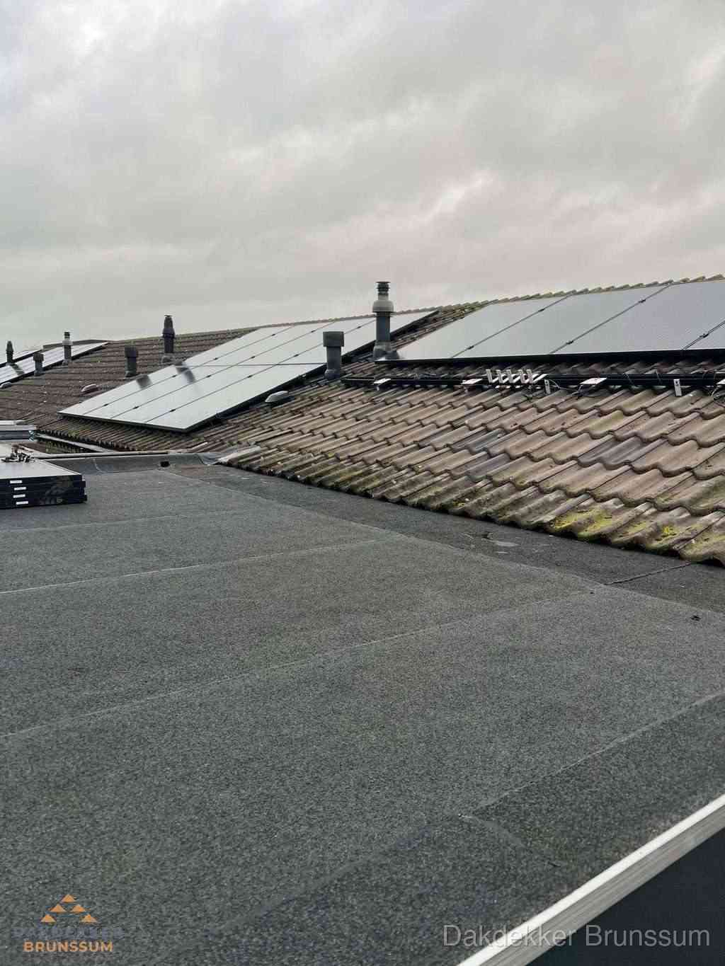 Plat dak inspectie met bitumen bedekking naast schuin pannendak in Brunssum