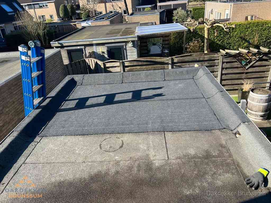 Dakdekker legt onderlaag op plat dak met houten constructie in Brunssum