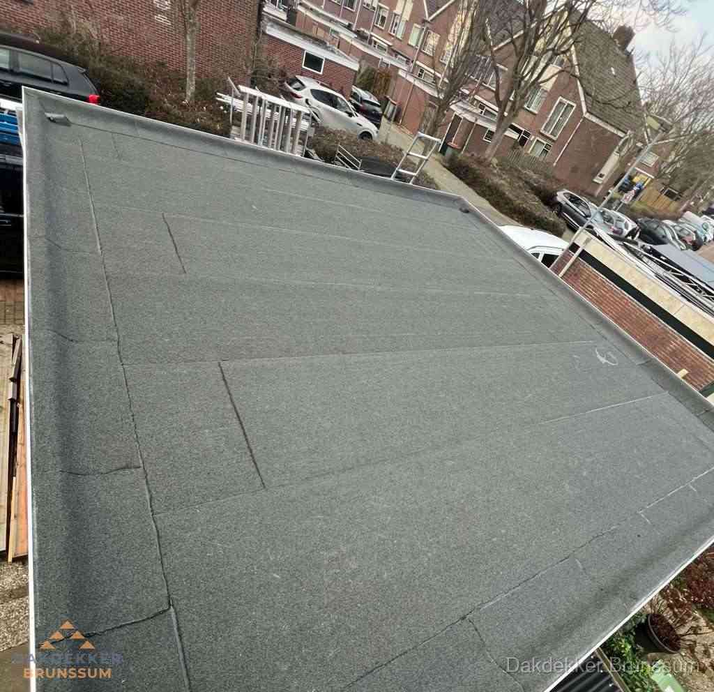 Nieuwe bitumen dakbedekking op plat dak van garage in Brunssum