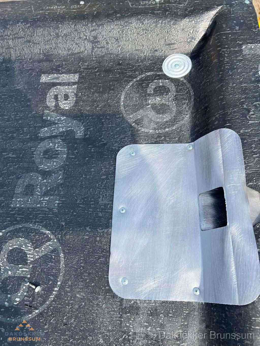 Dakdoorvoer met metalen afvoerplaat op bitumen dak in Brunssum