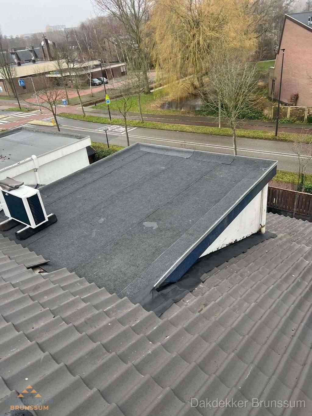 Plat dak met bitumen dakbedekking naast schuin pannendak in Brunssum