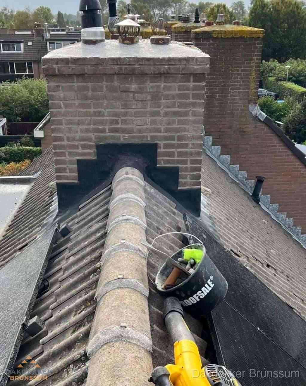 Dakdekker repareert bitumen dakleer bij dakdoorvoer in Brunssum